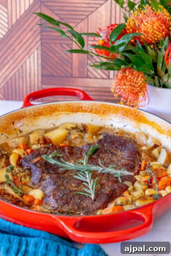 Ultimate Comfort Pot Roast with Tender Potatoes 11 A perfect pot roast and potatoes recipe, beautifully cooked and presented in a vibrant red Dutch oven.