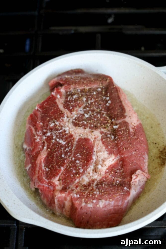 Ultimate Comfort Pot Roast with Tender Potatoes 7 A seasoned chuck roast placed in a pan, ready for searing.
