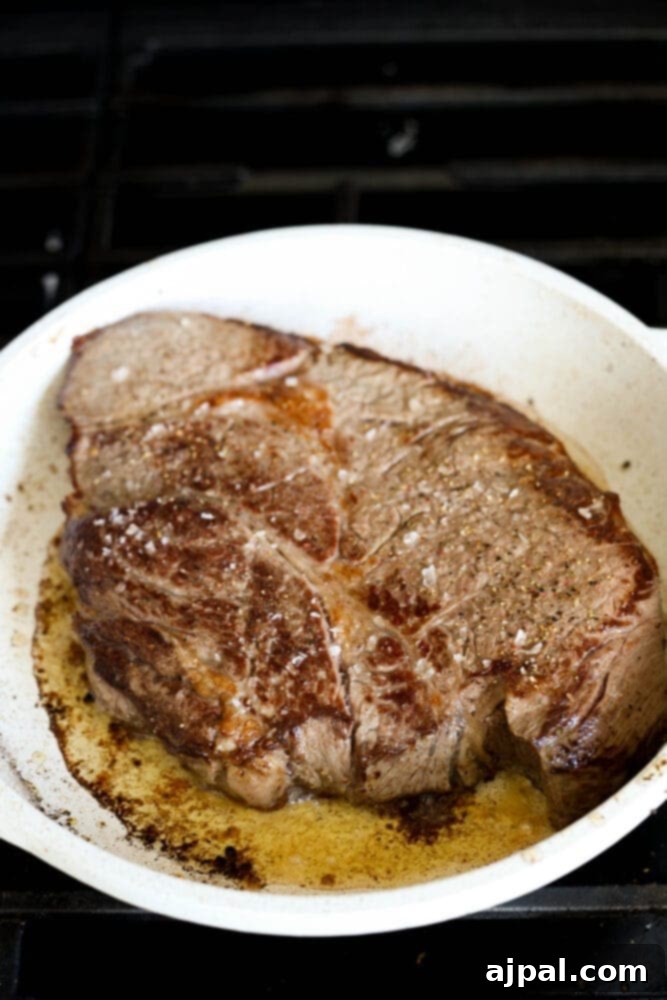 Ultimate Comfort Pot Roast with Tender Potatoes 8 A browned pot roast sizzling in a pan, displaying a rich, caramelized crust.