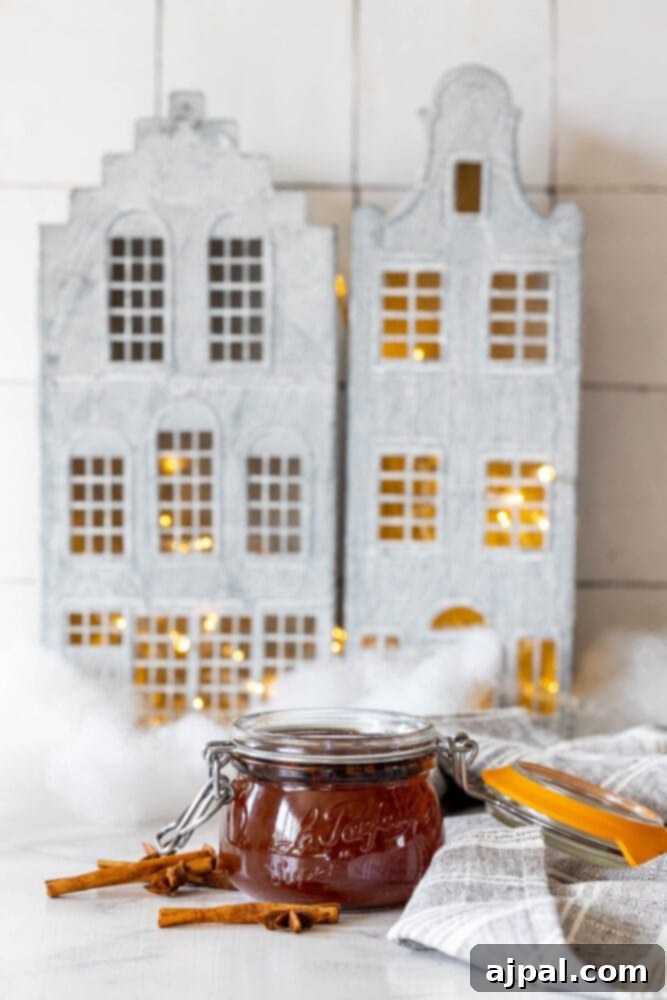 Warming Winter Spice Syrup 7 A jar of Mulled Simple Syrup, a spiced simple syrup recipe, next to a house on a table.