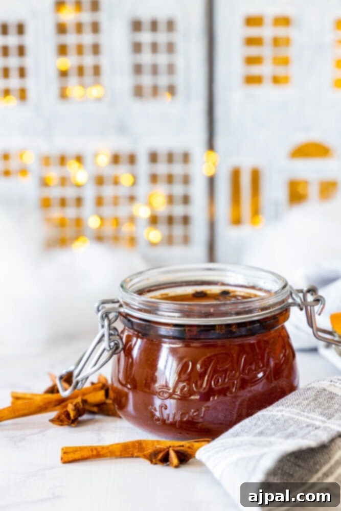 Warming Winter Spice Syrup 6 A jar of jam with cinnamon sticks on a table, flavored with spiced simple syrup recipe.