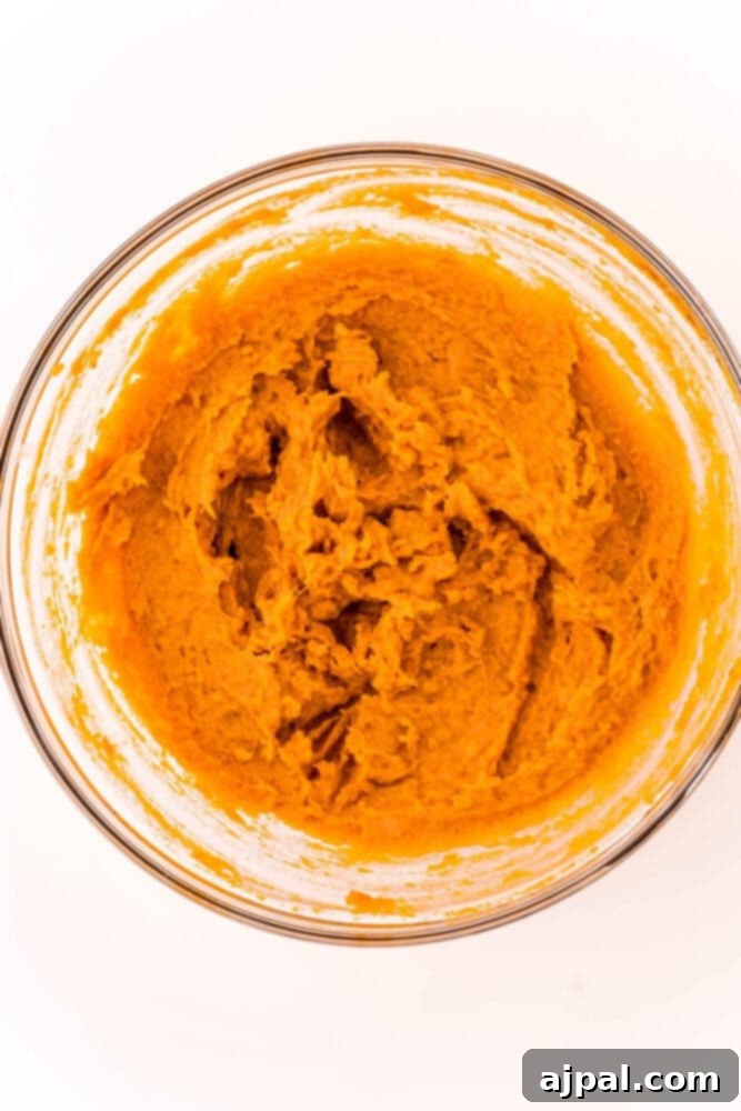 A bowl filled with a creamy, perfectly mixed sweet potato pie filling, showcasing its smooth texture and rich color, ready for baking.