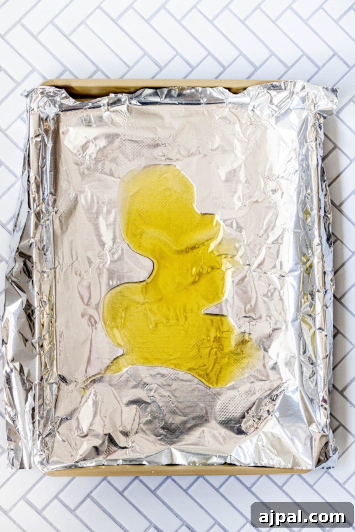 Chopped potatoes on a baking sheet with olive oil.