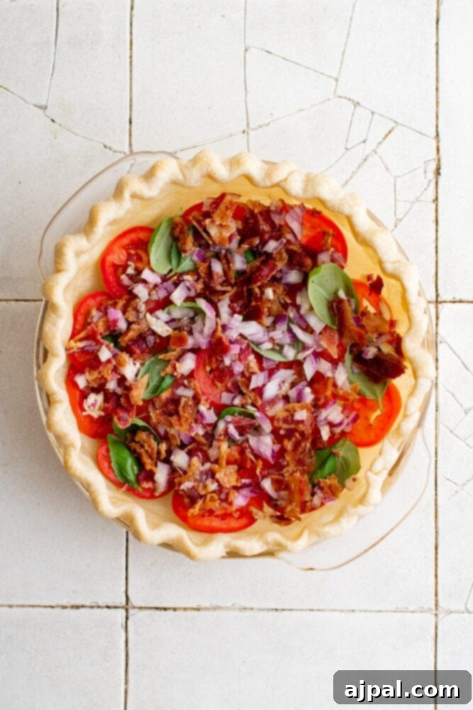 Simple Savory Tomato Pie 12 Sliced red onions generously sprinkled over layers of tomatoes and basil in a pie crust.