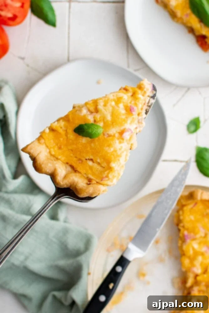 Simple Savory Tomato Pie 18 A perfect slice of tomato pie with fresh basil on a fork, ready to be eaten.