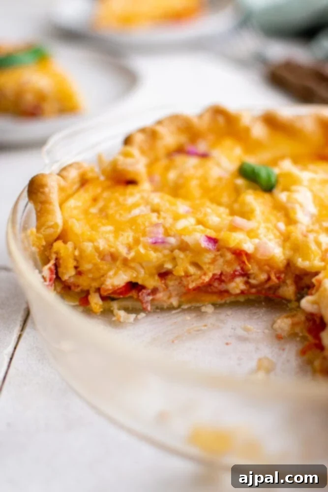 Simple Savory Tomato Pie 4 A baked tomato pie with a slice carefully removed, revealing its delicious layers.