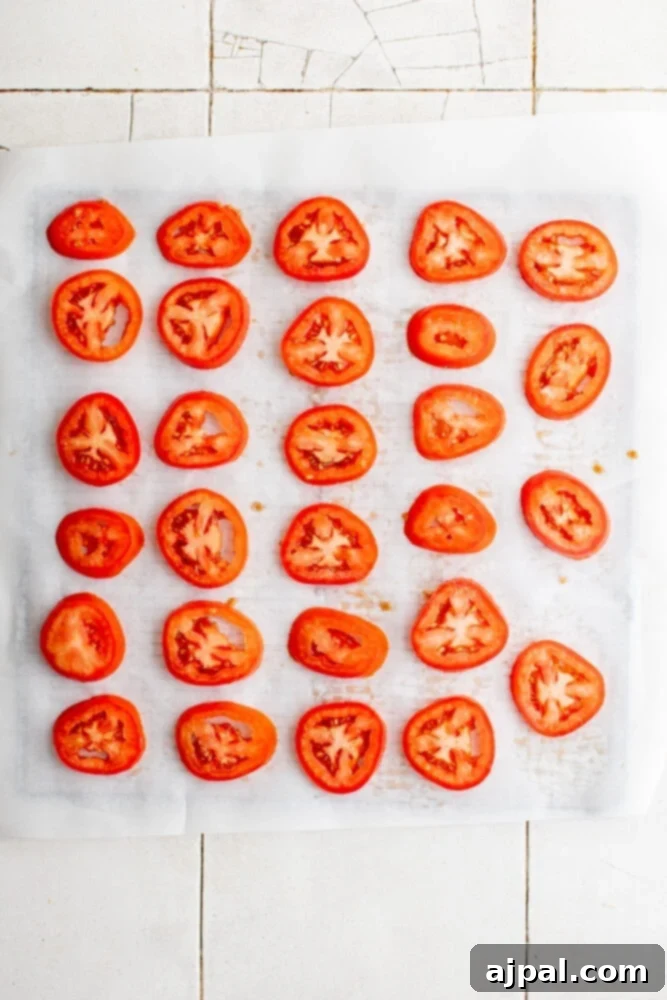 Simple Savory Tomato Pie 6 Thinly sliced tomatoes generously sprinkled with salt, resting on parchment paper to draw out moisture.
