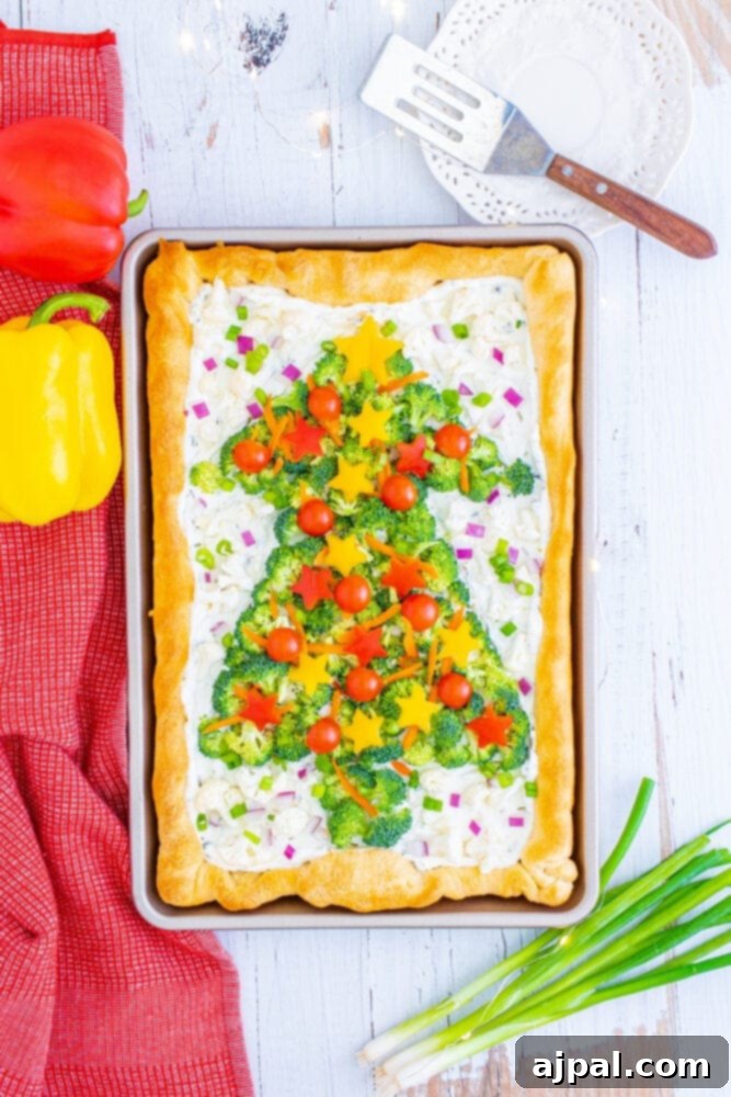 Bell pepper stars and fresh scallions complete the Christmas tree design on the vegetable pizza, creating a vibrant holiday appetizer.