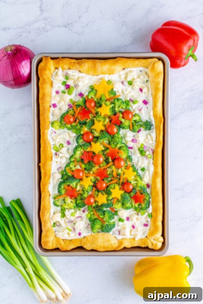 The finished Christmas tree vegetable pizza, brimming with colorful veggies, is ready for slicing and serving as a festive holiday treat.