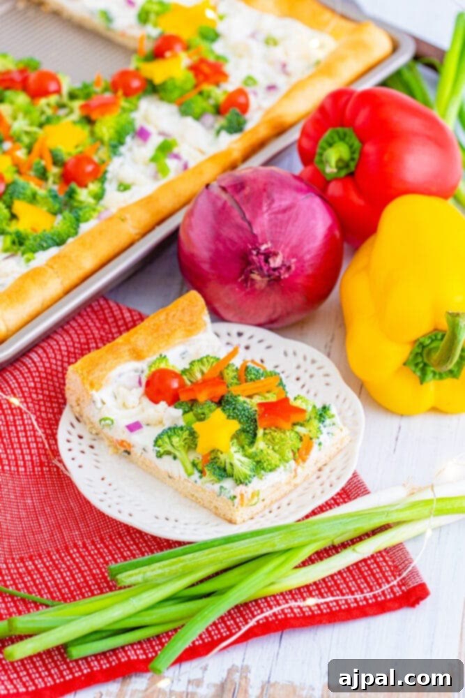 A vibrant Christmas tree vegetable pizza with its crisp crust and colorful toppings, viewed from an appealing angle.