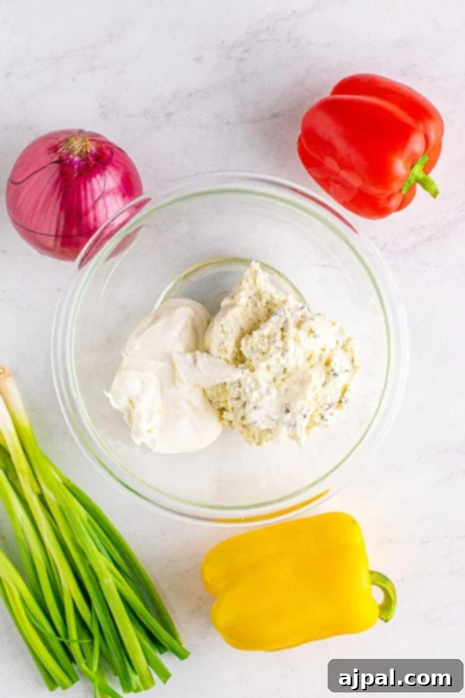 A bowl of creamy chive cream cheese, perfectly whipped and ready to be spread, showcasing its smooth texture.