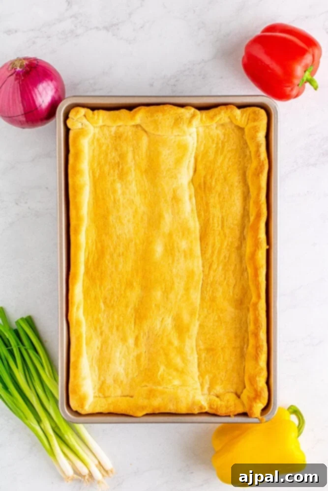 A perfectly baked, golden-brown crescent dough crust, cooled and ready to be topped, showcasing its flaky texture.