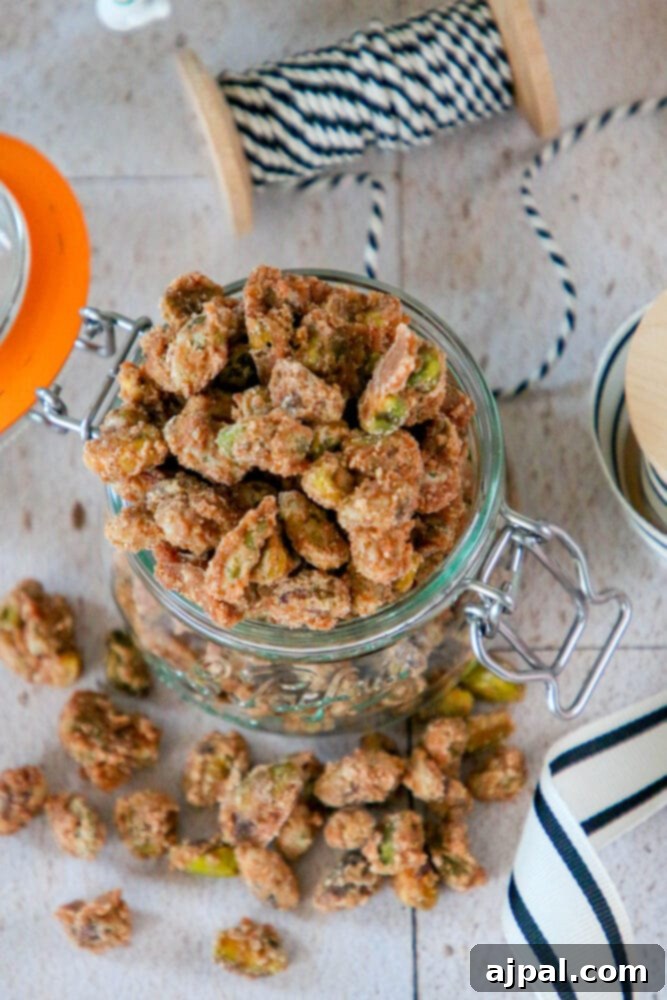 Close-up of a single candied pistachio, perfectly coated with a sweet, spiced glaze, showcasing its delightful texture and color.