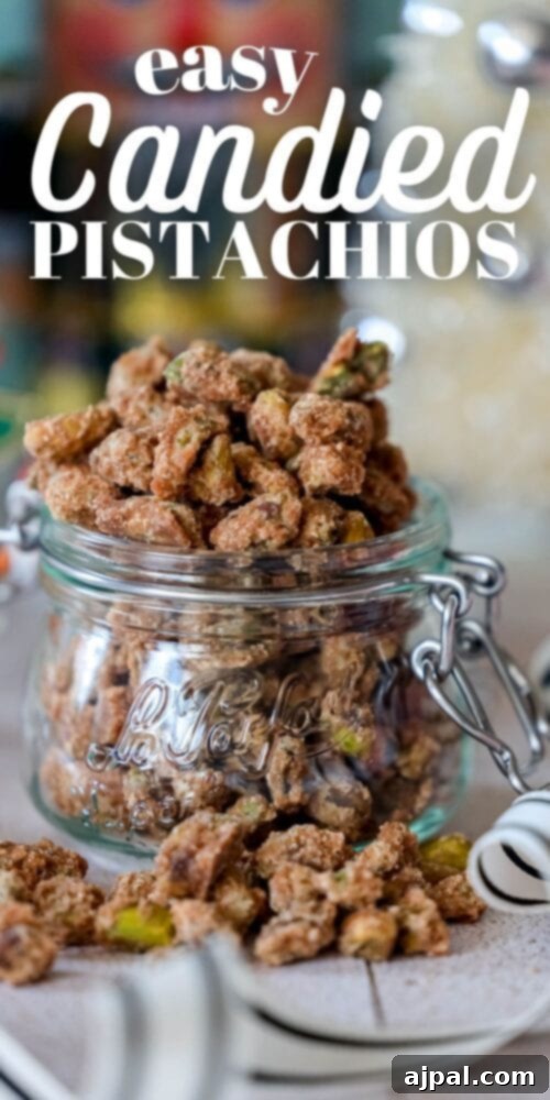 A tall glass jar filled with perfectly easy candied pistachios, featuring a sweet and salty cinnamon coating, perfect for a holiday treat.