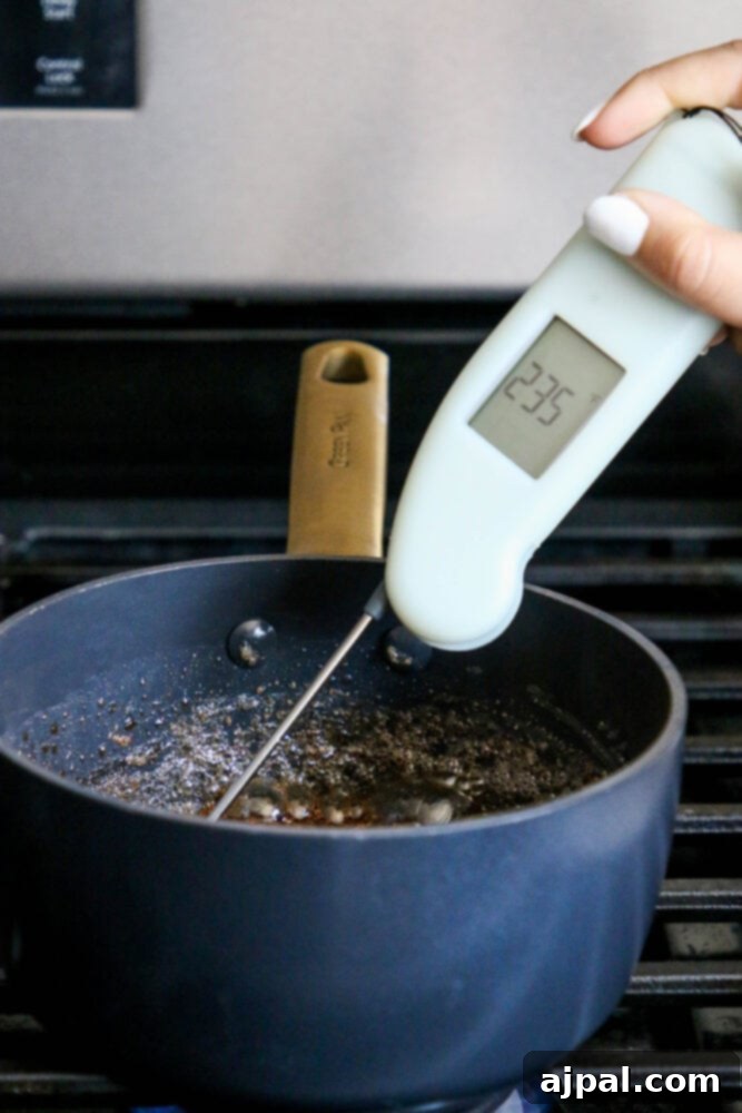 A saucepan on a stovetop with a candy thermometer, capturing the precise moment of creating the candy coating for pistachios.
