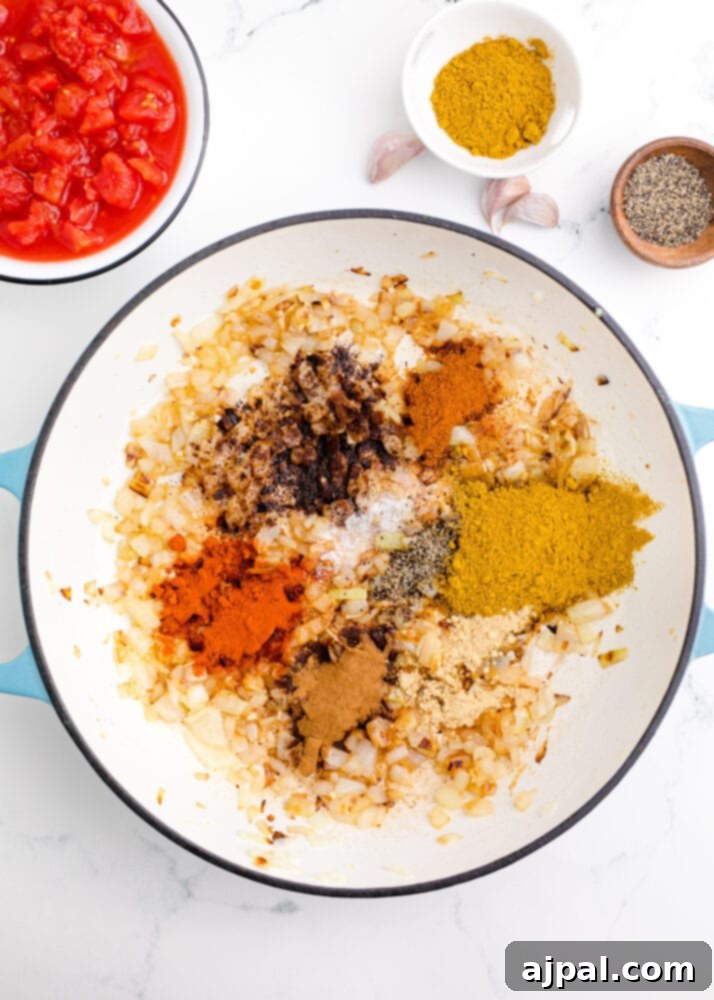A bowl filled with a colorful array of Madras curry spices: vibrant red chili powder, yellow curry powder, and other aromatic blends.