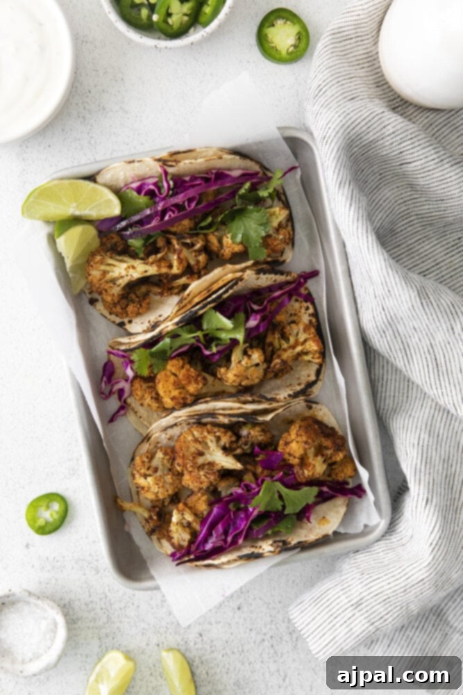 Your New Favorite Vegan Cauliflower Tacos 2 picture of cauliflower tacos with vegan crema and slaw in a metal tray