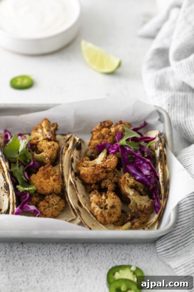 Your New Favorite Vegan Cauliflower Tacos 3 picture of cauliflower tacos with vegan crema and slaw in a metal tray