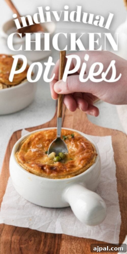 A spoon dipping into a white ramekin containing a delightful individual chicken pot pie.