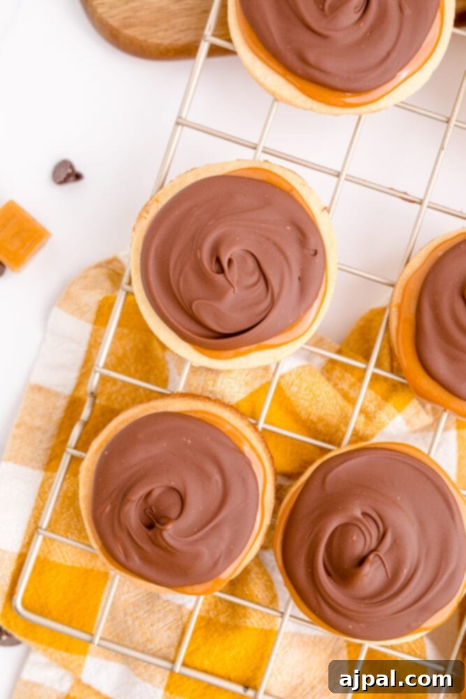 picture of chocolate peanut butter Twix cookies on a cooling rack, showcasing their delicious layers and readiness to be enjoyed.