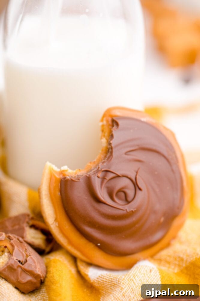 A plate of chocolate caramel Twix cookies accompanied by a refreshing glass of milk, inviting a delightful indulgence.