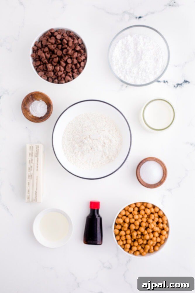 picture of twix cookies ingredients on a table, including butter, powdered sugar, vanilla, baking powder, flour, caramel bits, milk, chocolate chips, and oil.