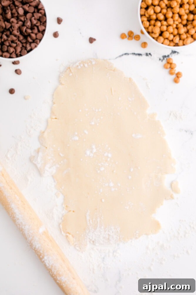 picture of shortbread cookie dough being rolled out on a table dusted with flour, demonstrating the preparation process.