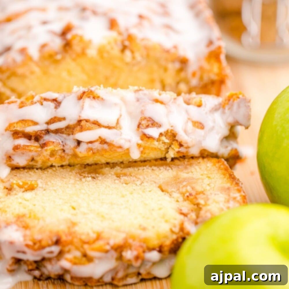 Sliced apple fritter bread on a cutting board with a green apple beside it, ready to be enjoyed.