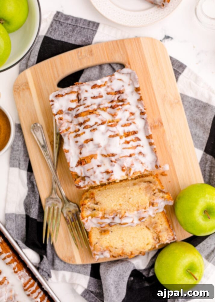 An inviting slice of apple fritter bread presented on a rustic cutting board, highlighting its moist texture.