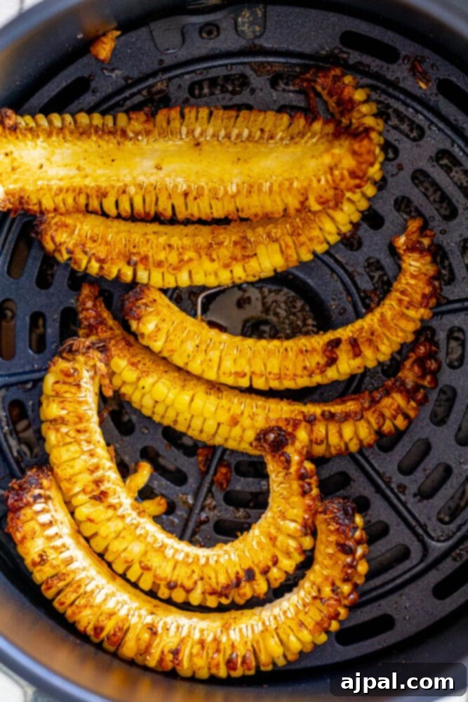 Golden-brown corn ribs perfectly air-fried and ready to enjoy, in an air fryer basket.