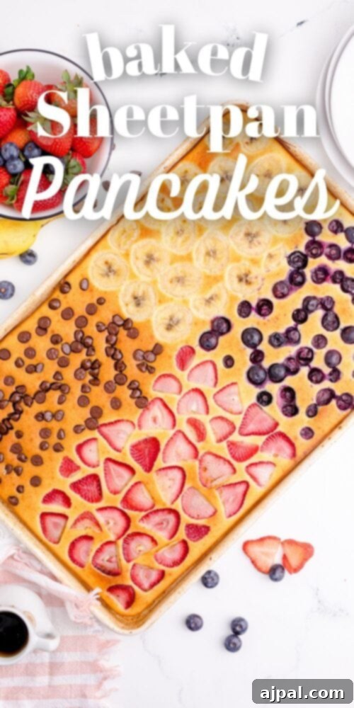 A vibrant overhead shot of baked sheet pan pancakes in a baking sheet, generously adorned with an assortment of fresh fruits like berries and sliced bananas, ready to be served for an inviting breakfast.