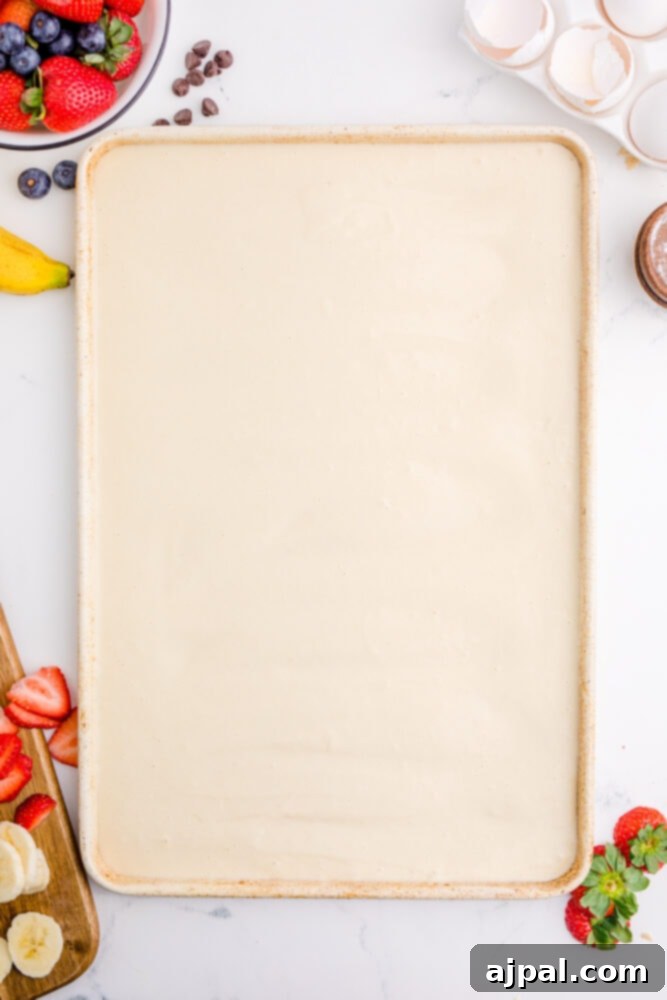 A close-up shot of light, airy pancake batter resting in a baking sheet, showcasing its perfect consistency before baking.