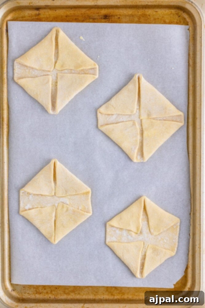 Squares of puff pastry dough neatly arranged on a baking sheet, prepped for filling.