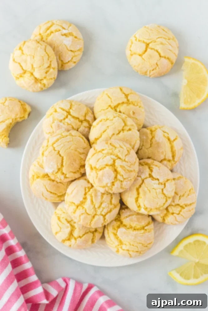 A plate of freshly baked lemon crinkle cookies, dusted with powdered sugar, showcasing their soft texture and inviting appearance.