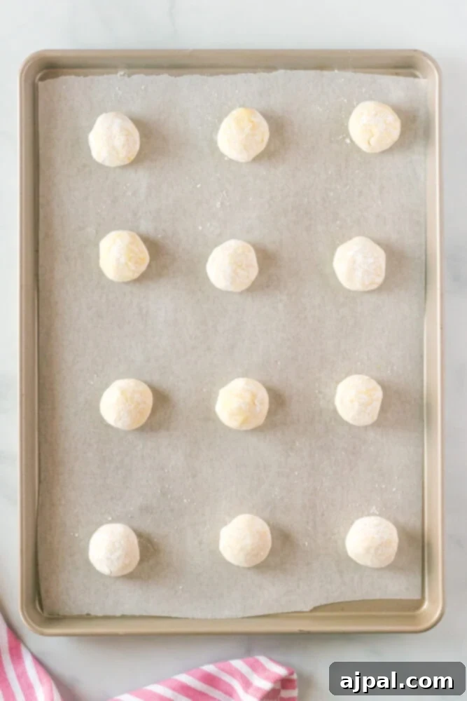 picture of cookie dough ball rolled in sugar on a baking sheet