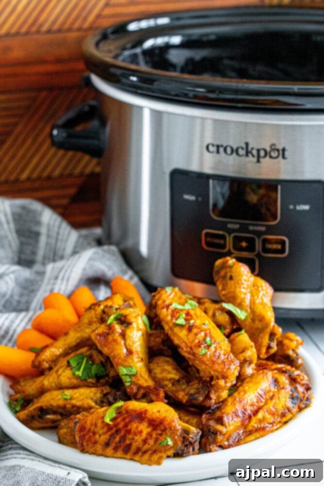 Smoky Tinga Slow Cooker Wings 10 A vibrant plate of Slow Cooker Tinga Chicken Wings and carrots, beautifully presented in front of a slow cooker.