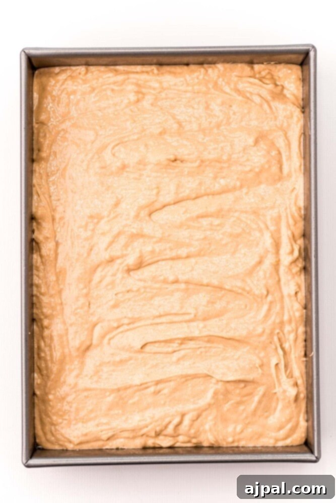 Ultimate Peanut Butter Cake 7 Peanut butter cake batter poured evenly into a rectangular baking pan, ready for the oven.