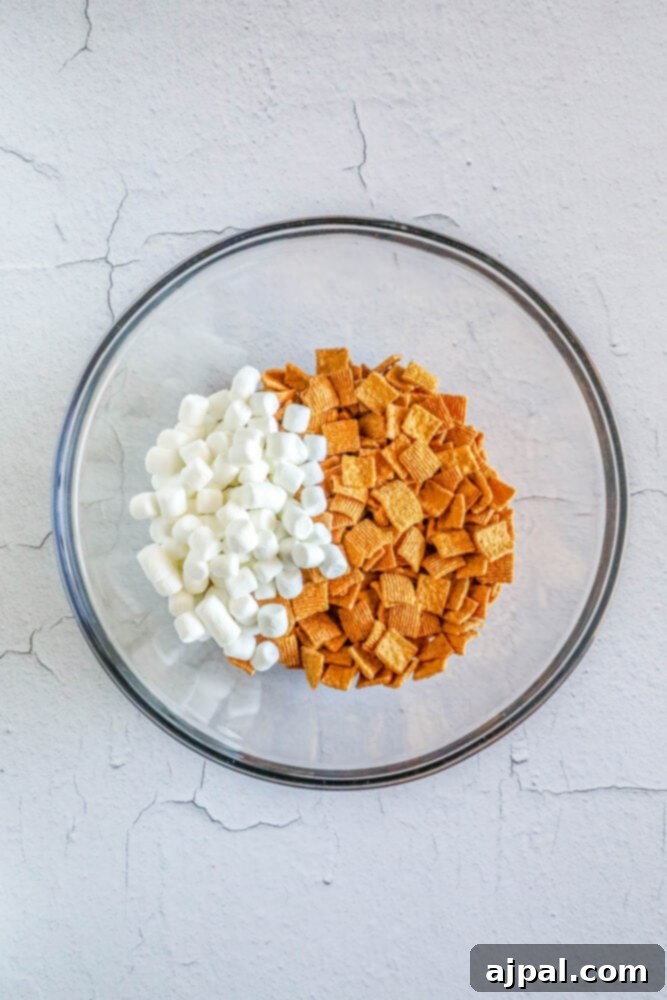 Valentine Smores Snack Mix 4 Golden Grahams cereal and mini marshmallows in a bowl, ready to be mixed for a Valentine's S'mores Snack Mix.