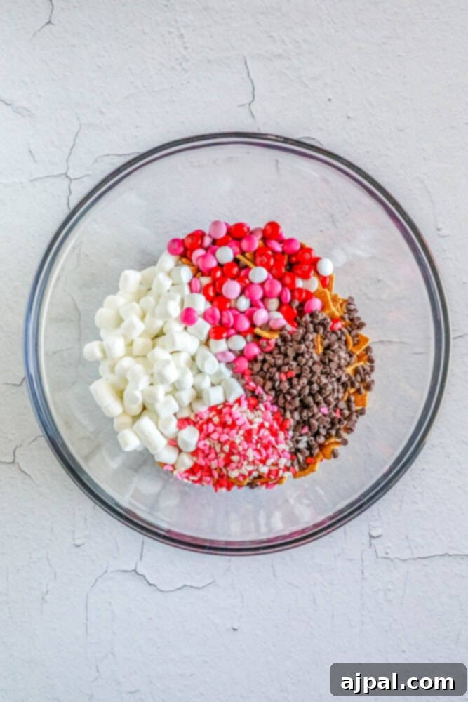 Valentine Smores Snack Mix 7 The completed Valentine's S'mores Snack Mix in a bowl, featuring Golden Grahams, marshmallows, pink M&M's, sprinkles, and chocolate chips.