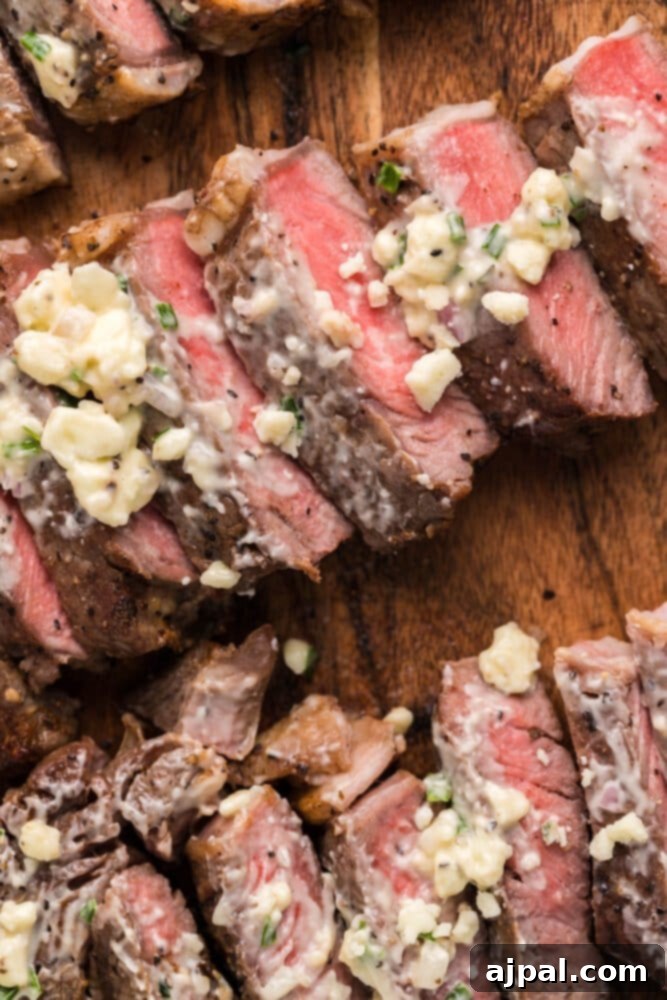 Grilled New York Strip steak with a vibrant topping of blue cheese on a rustic cutting board, garnished with fresh herbs.
