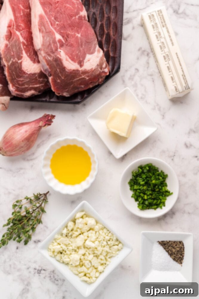 Assortment of fresh ingredients including New York Strip steaks, butter, blue cheese, and various herbs laid out on a table, ready for preparation.