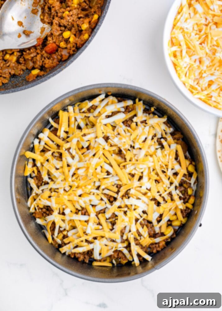Hearty Taco Bake 8 A layer of meat mixture spread over a tortilla in the springform pan.
