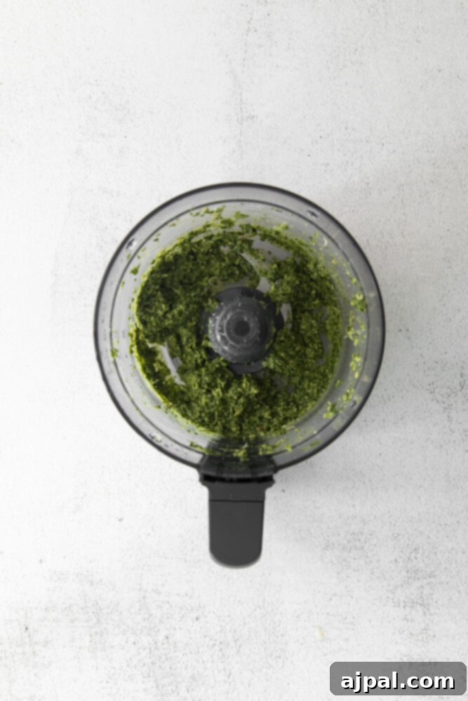 Vibrant Pesto Hummus 5 picture of basil in a food processor