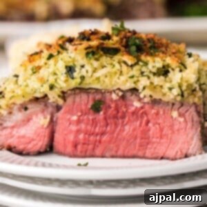 parmesan encrusted steak on a white plate in front of an air fryer