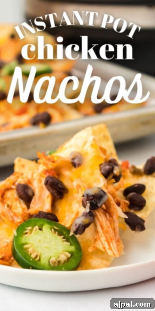 Picture of chicken nachos on a baking sheet, with vibrant toppings and melted cheese
