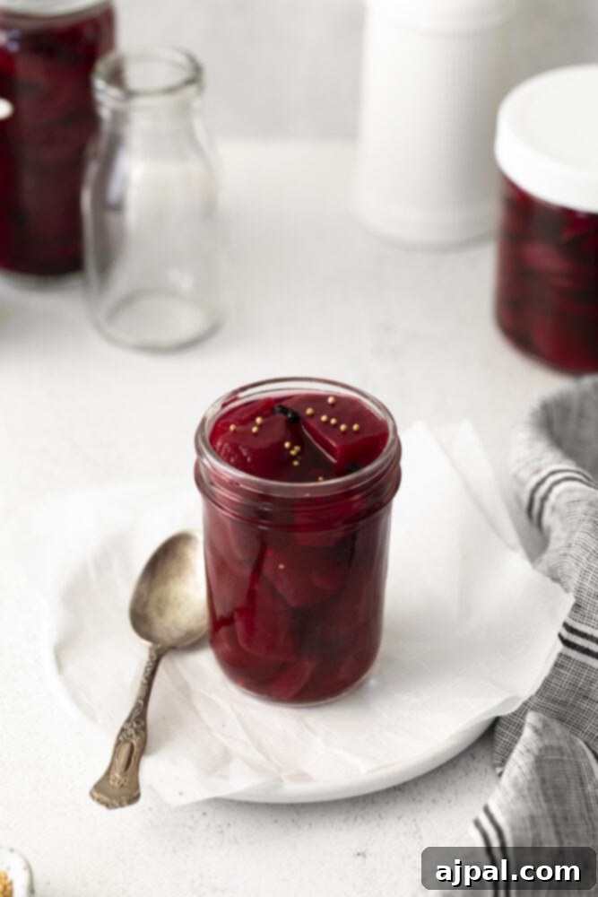 A jar of quick pickled beets on a rustic wooden surface, highlighting the vibrant color.