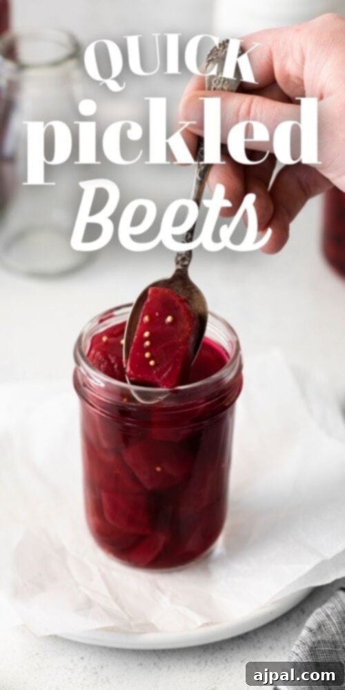 A jar of quick pickled beets with a spoon, highlighting the vibrant color and deliciousness of the recipe.