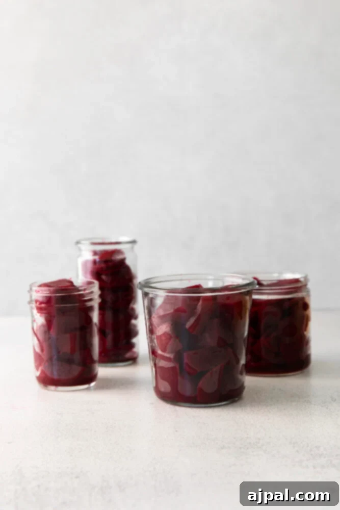 Cooked beets being placed into a jar.