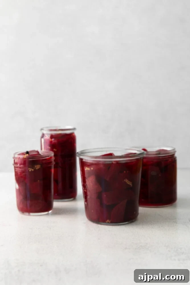 Beets fully submerged in pickling liquid inside a jar.