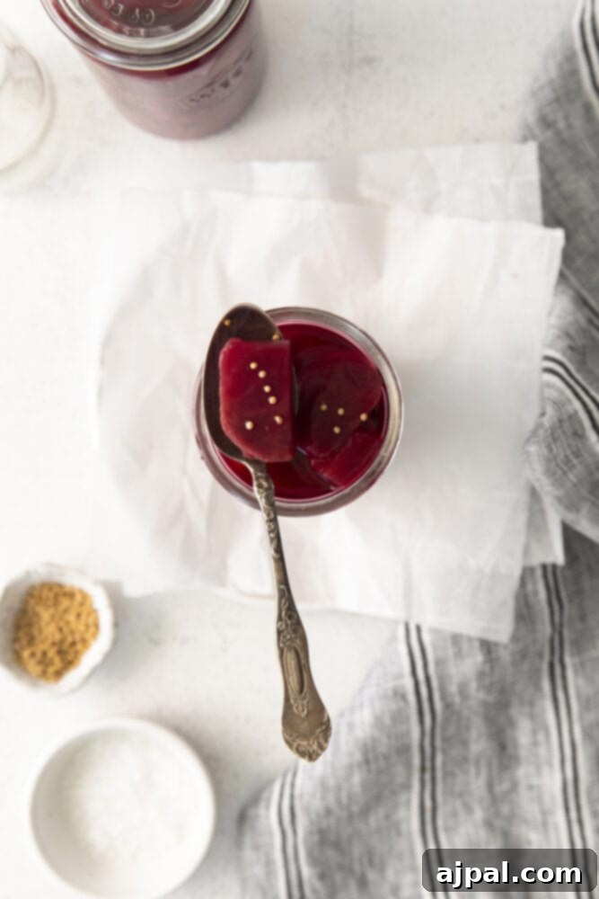 A jar of quick pickled beets with a spoon inside, ready to be served.